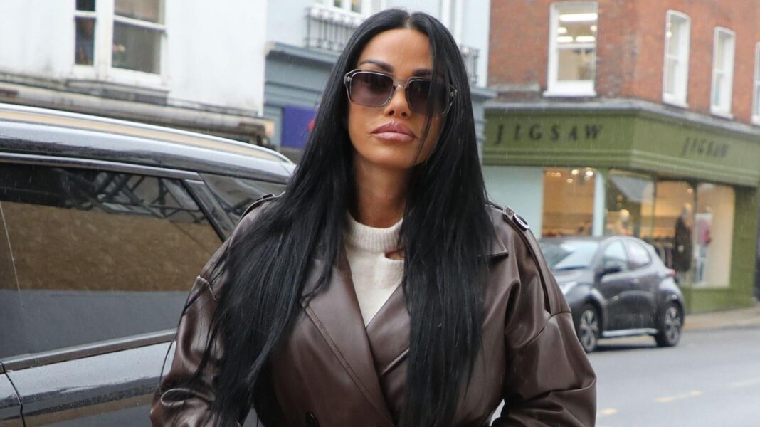 Katie Price ‘really shocked’ by ex-husband rape claims Katie Price wearing a brown leather coat, cream jumper and dark sunglasses standing near a road.