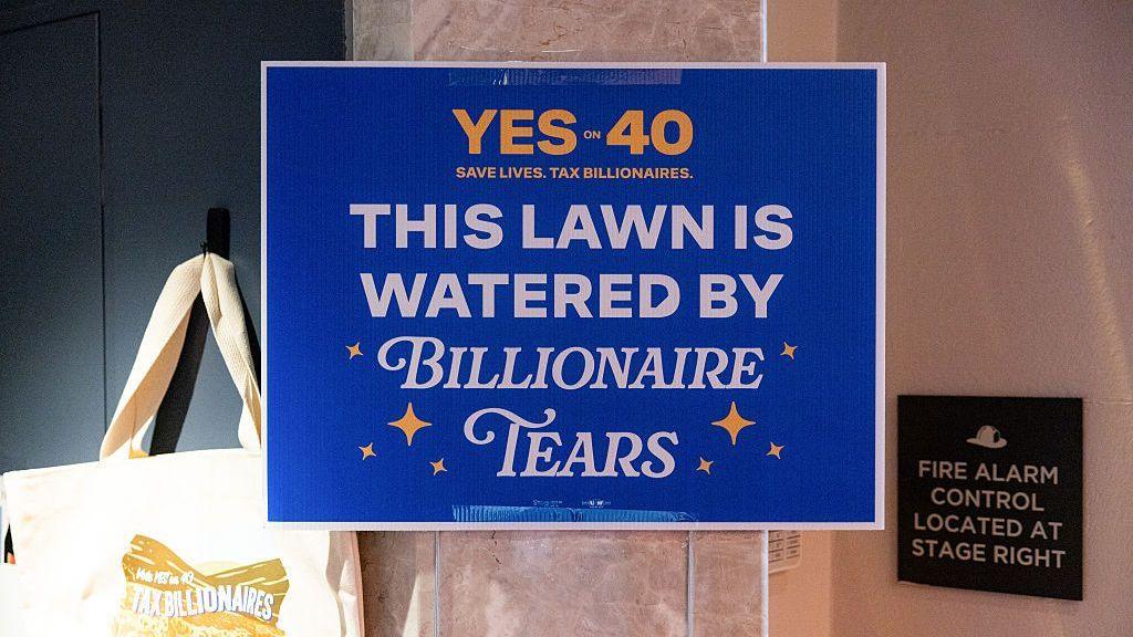 A "Yes to 40 This Lawn Is Watered By Billionaire Tears" yard sign among merchandise for sale during a "Yes on 40 for Ballots Over Billionaires" rally in San Francisco, California, US, on Saturday, Oct. 3, 2026.
