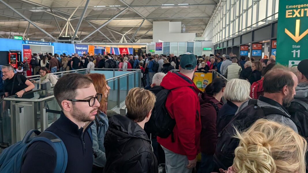 Long queues after power surge at Stansted Airport Large crowds inside an airport terminal. The people are queuing for immigration control.