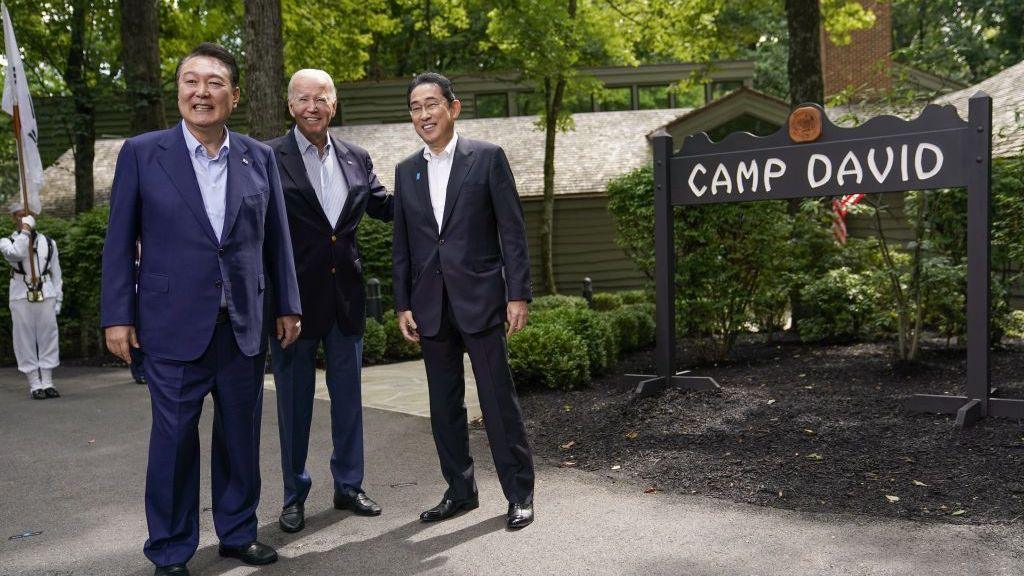US President Joe Biden, center, greets Fumio Kishida, Japan's prime minister, right, and Yoon Suk Yeol, South Korea's president, left, during a trilateral summit at Camp David, Maryland, US, on 18 August 2023