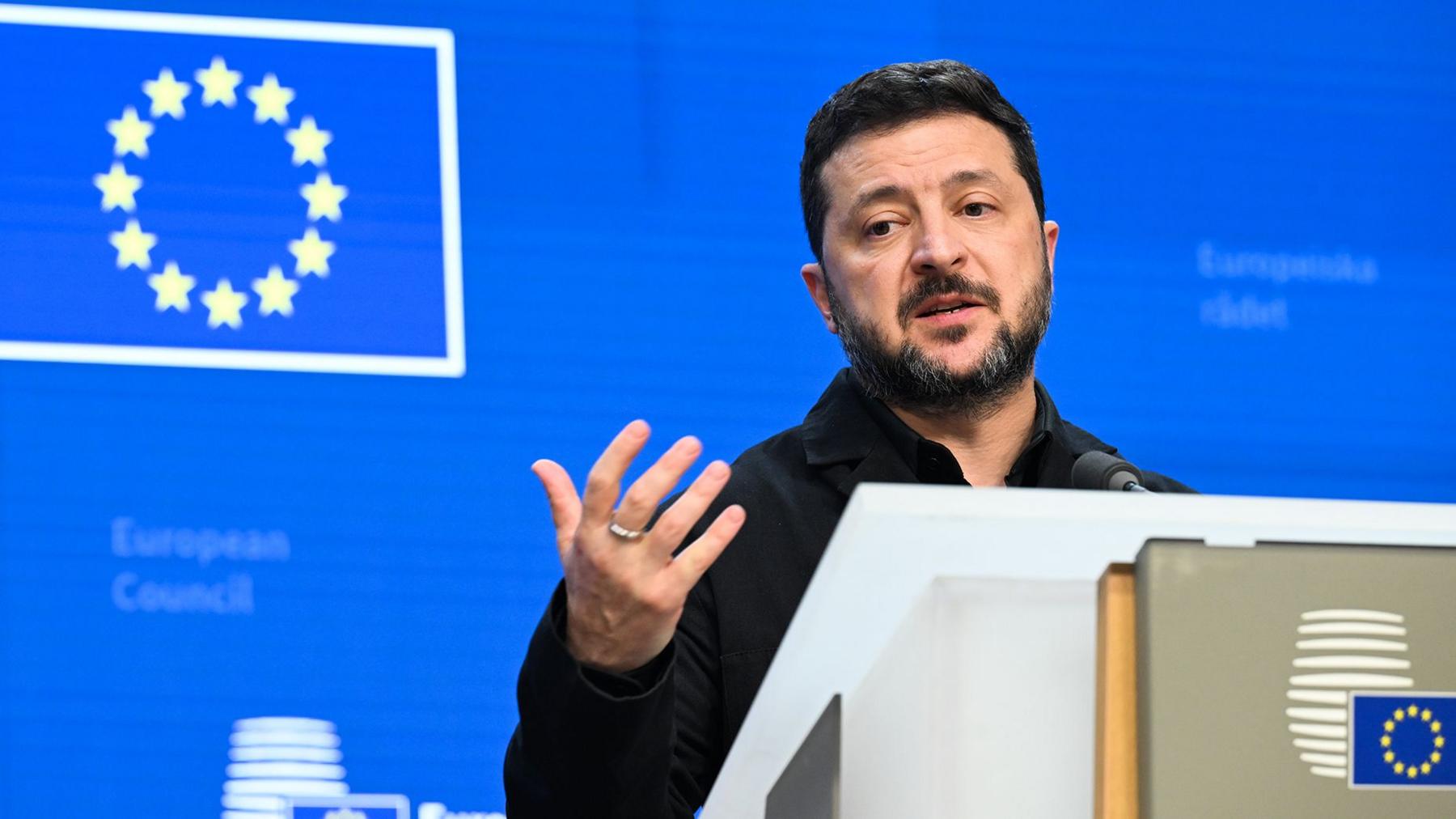 Zelensky speaks in Brussels in front of a blue background in front of European leaders