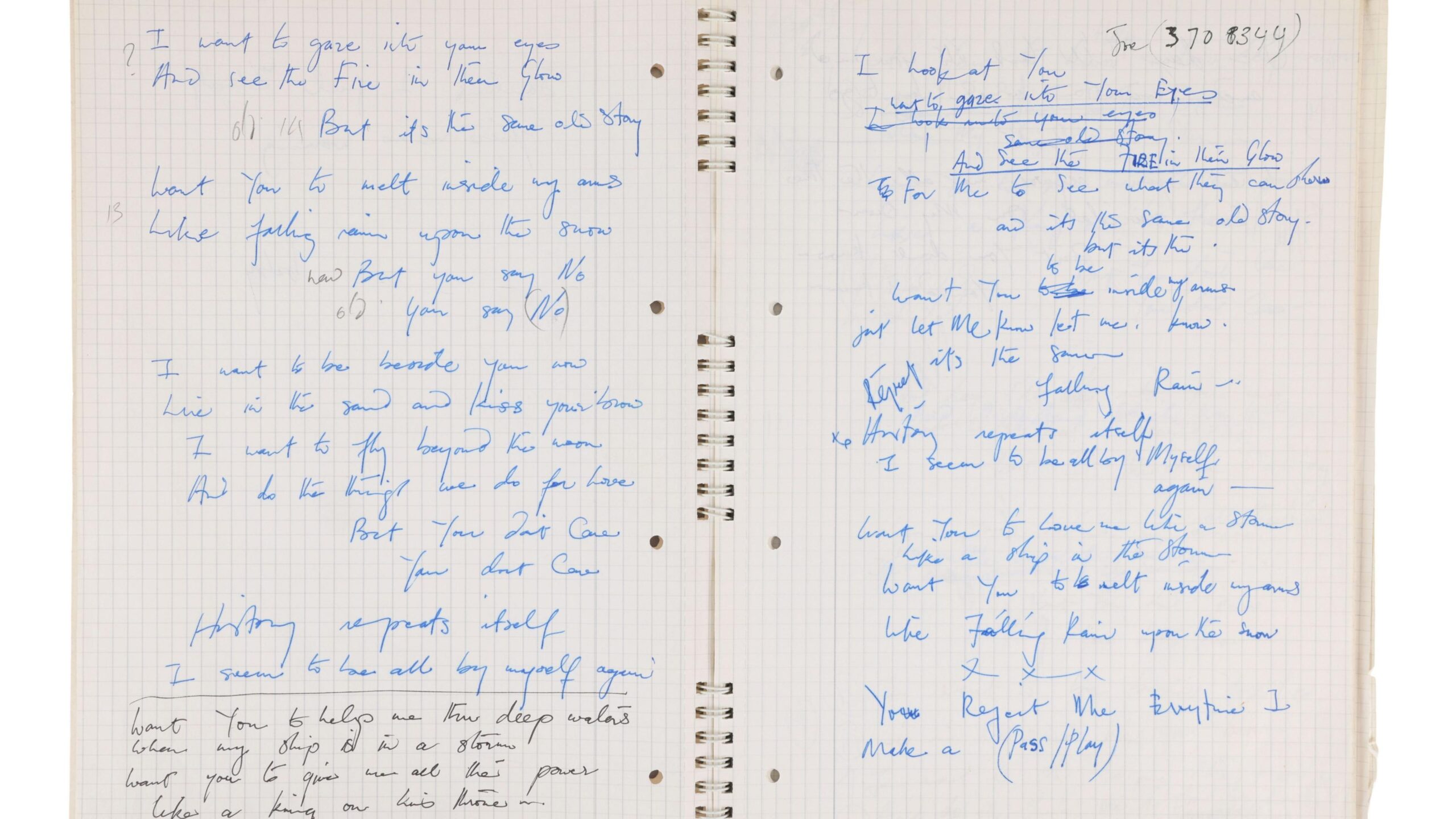 An open notebook with blue and black handwritten notes on squared paper. There are holes in the middle of the notebook.