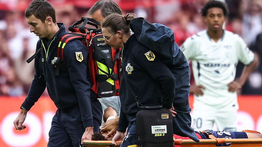 Lille's Tiago Santos is carried off the field on a stretcher after injuring his knee against Le Havre