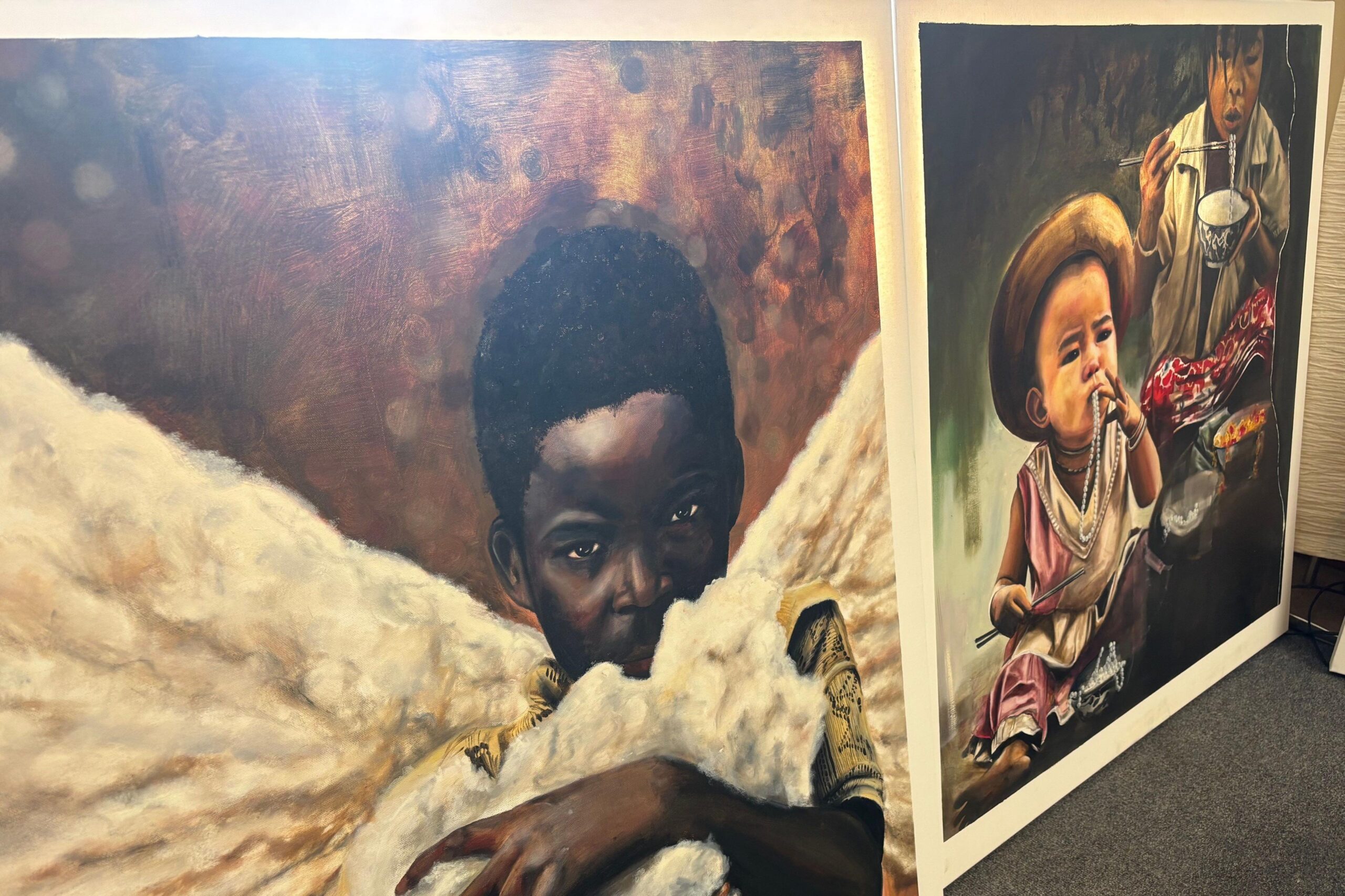 Two of Makenzy's paintings - one is of a boy flanked by what appears to be angel wings, another shows a mother and baby.