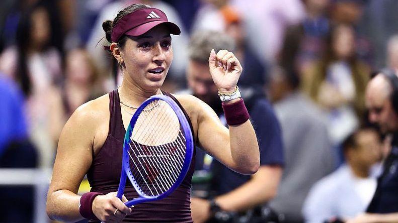 Jessica Pegula, in maroon outfit and cap, celebrates a victory as she clenches her left fist
