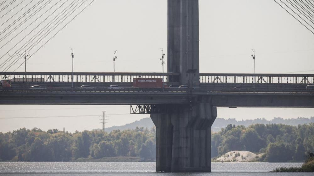 Cars drive across a bridge over the Dnipro River after it was hit during a Russian jet drone strike, amid Russia's attack on Ukraine, in Kyiv, Ukraine