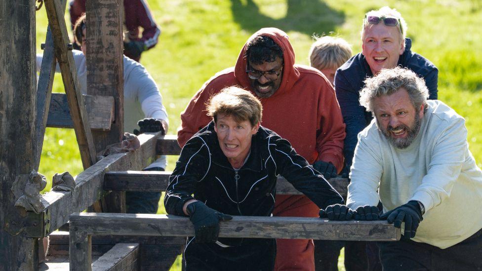 James Blunt, Romesh Ranganathan, Joe Lycett and Michael Sheen using the battering ram outdoors in the latest mission on Celebrity Traitors