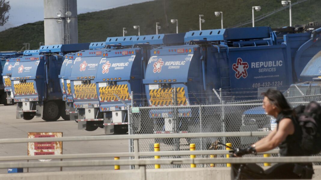 Living with a stink? Technology might help Blue rubbish trucks lined up at Newby Island landfill. A cyclist is in the foreground.
