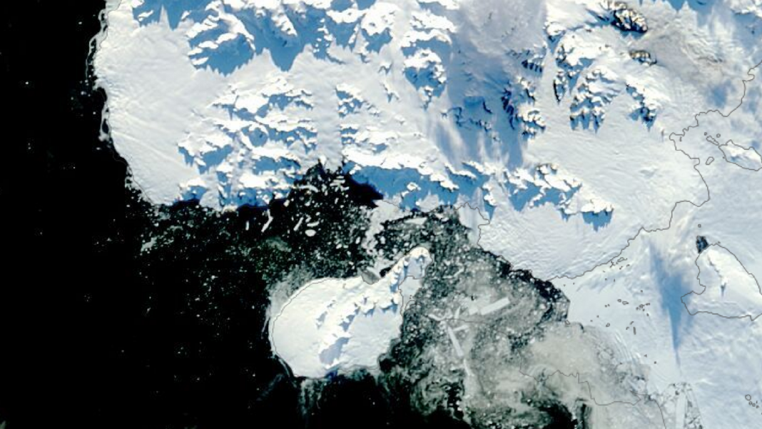 Part of Antarctica named after former BBC science correspondent Satellite image of Antarctica. To the left of the image is the ocean, which is black. A small white landmass, which is Rothschild Island, is at the centre bottom of the image. There is a large landmass to the right of the image, which is Alexander Island. The Amos Channel is a stretch of water between the northern tip of Rothschild Island and Alexander Island. The water of the Channel is black with broken ice in it.