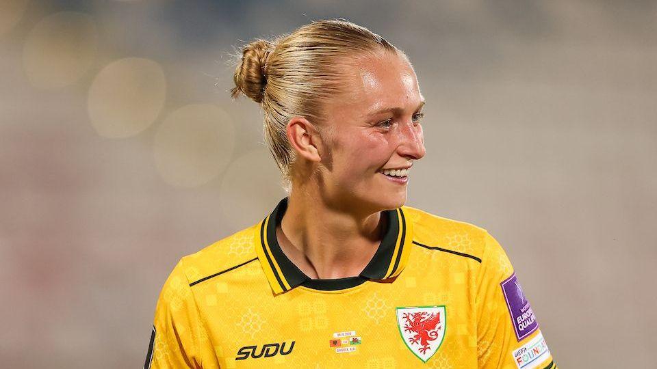 Elise Hughes smiles while chatting to team-mates during the game against Albania