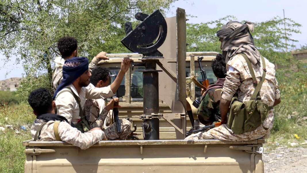 Yemeni military says it has ‘secured’ Red Sea waterway Several people ride in the back of a pick-up truck carrying mounted equipment along an unpaved road lined with trees and scrub