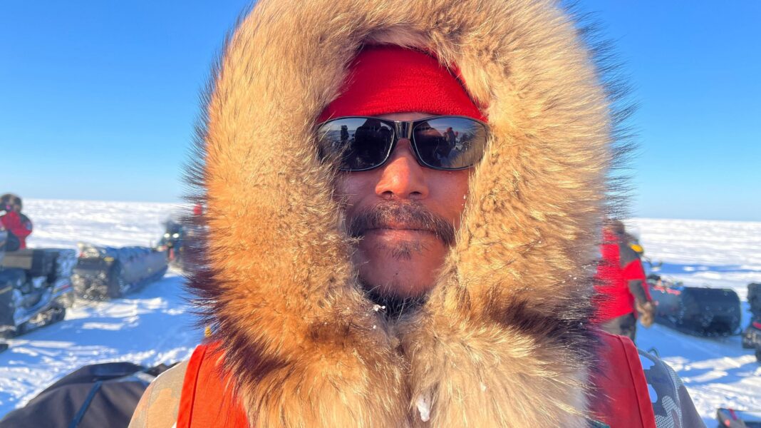 Barnie Aggark, an Inuk man, pictured wearing a hood with a thick fur trim and sunglasses