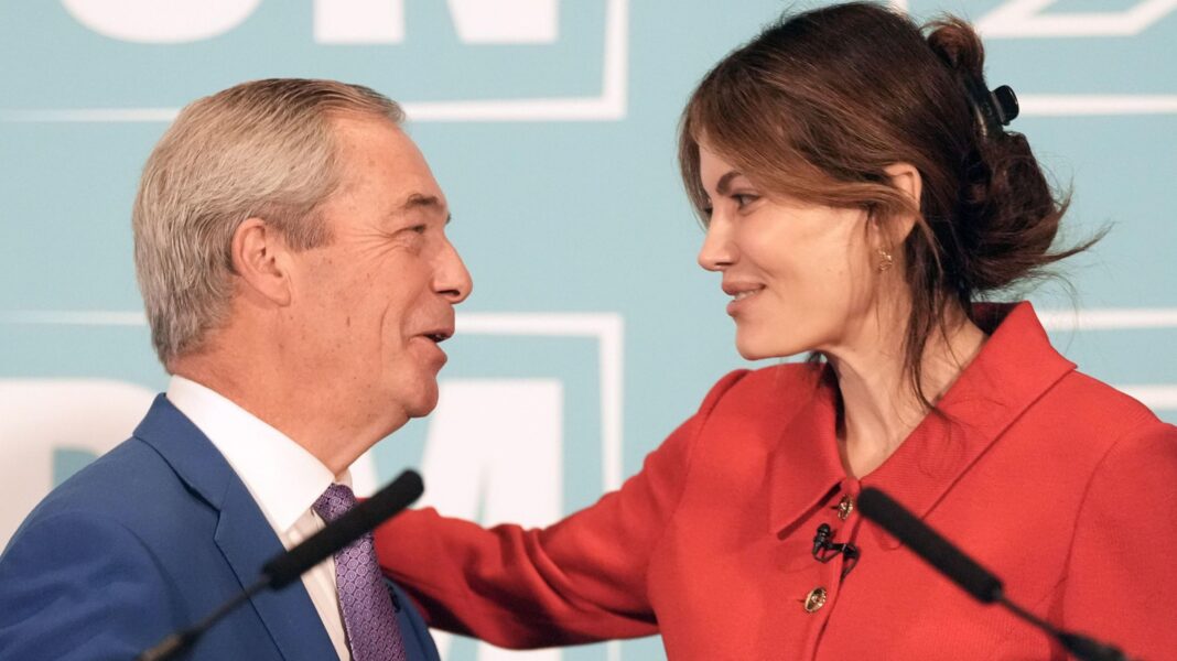 Nigel Farage and Laila Cunningham embrace at a podium in front of a press conference