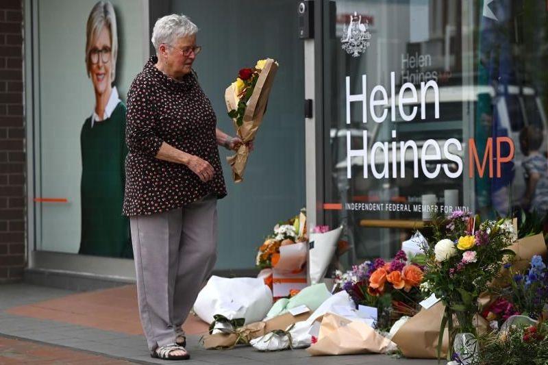 A woman lays flowers outside Helen Haines' office in Wangaratta