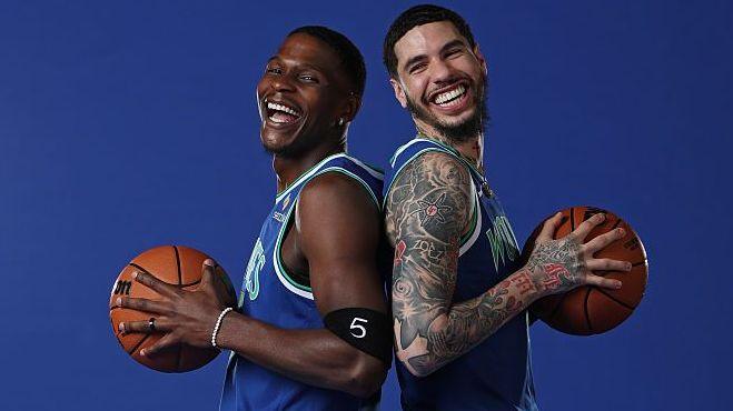 LaMelo Ball #1 & Anthony Edwards #5 of the Minnesota Timberwolves pose for a portrait in blue vests leaning back-to-back, both holding basketballs