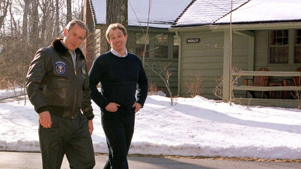 Then-U. S. President George W Bush and then-British Prime Minister Tony Blair taking a walk on the grounds of presidential retreat Camp David in 2001