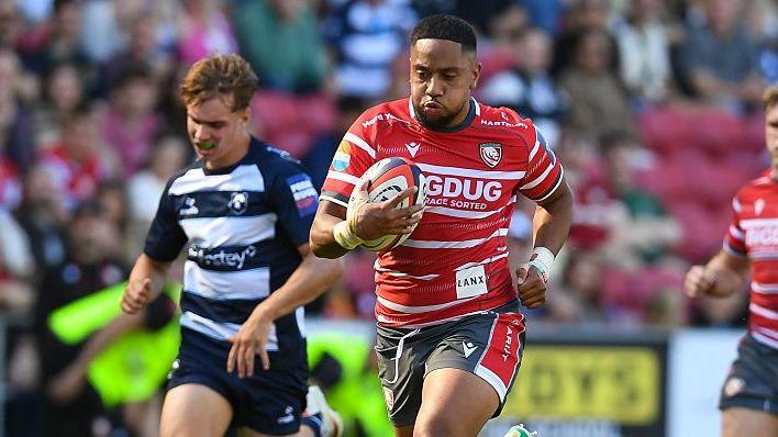 Phil Cokanasiga runs with the ball tucked under his right arm to his chest during a Prem Rugby Cup game for Gloucester