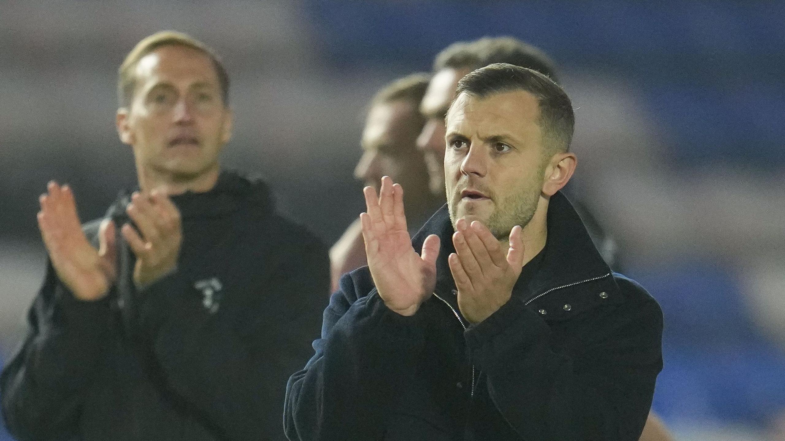 Luton boss Jack Wilshere claps the Luton fans at the end of their victory at Peterborough with his backroom team in the background