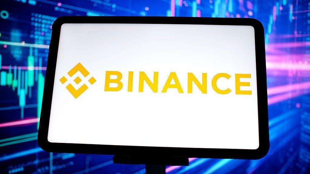 A tablet with a white background and the yellow Binance logo on it against a blue background