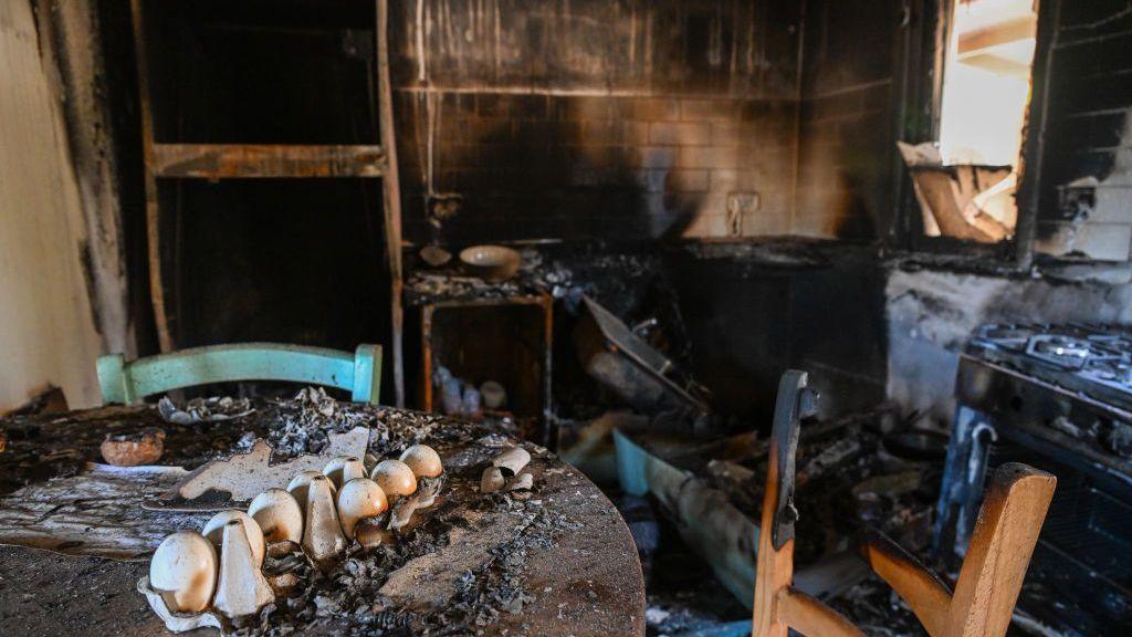 A burnt kitchen, blackened with smoke and charred furniture.