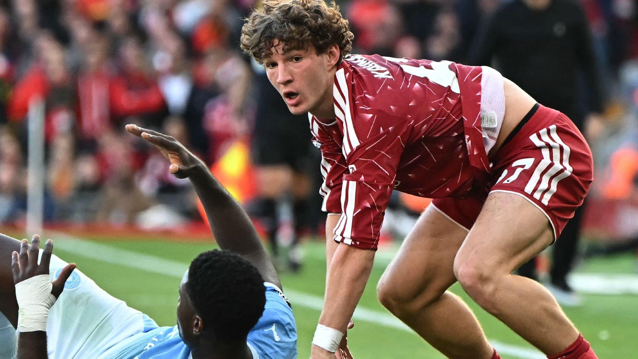 Lewis Koumas in Liverpool's red and Marc Guehi of Manchester City on the ground in blue