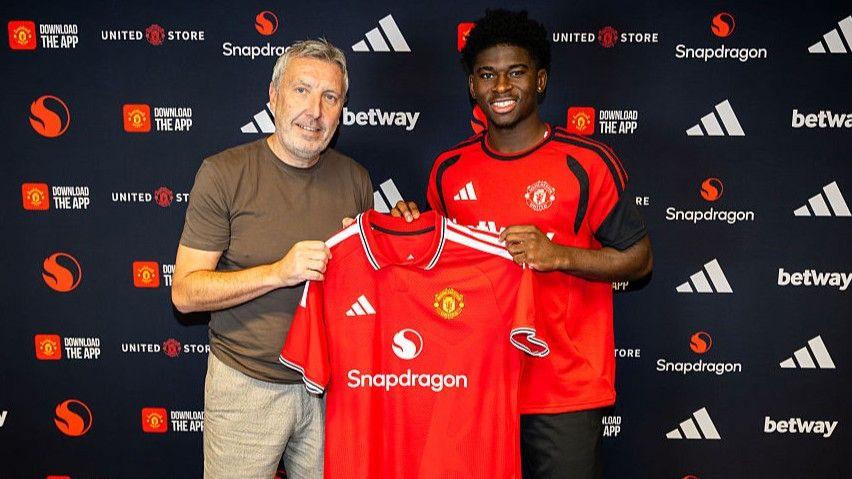 Manchester United director of football Jason Wilcox with £70m new signing Carlos Baleba