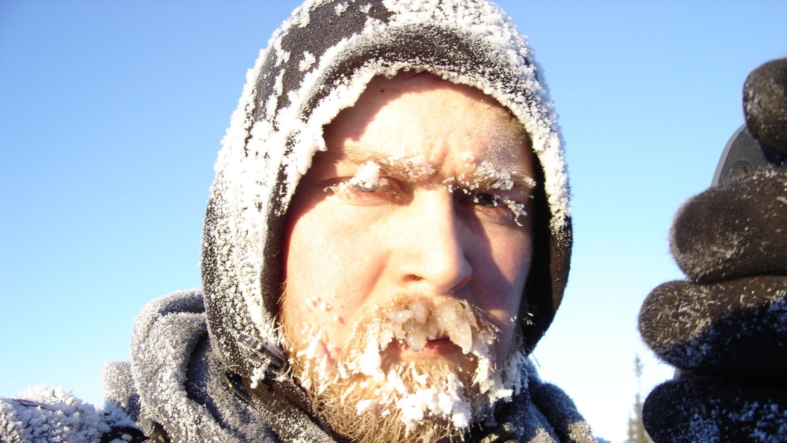 Karl Bushby, with a thick beard covered in snow and ice. He has a hood up.