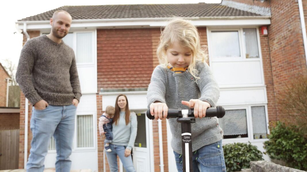 ‘Painful’ years ahead, think tanks warn, as living standards set to fall Family outside a house including a man, woman with a small child on her hip and another small child riding a scooter in the foreground