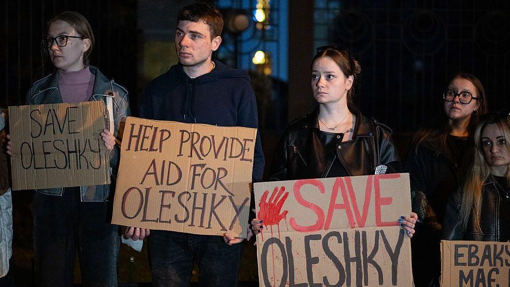 Activists hold placards with slogans during a rally in support of residents of Oleshky, Kherson region, calling on the international community to draw attention to the humanitarian situation in the Russian-occupied city.