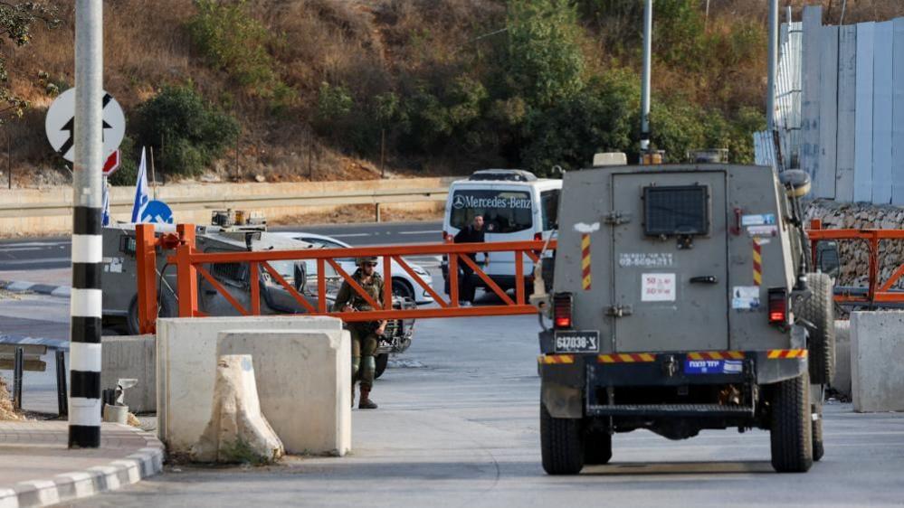 An Israeli army vehicle passes near the closed entrance of Hebron, in the Israeli-occupied West Bank