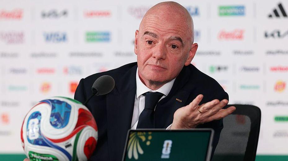 Gianni Infantino pictured at a news conference at the 2026 Fifa World Cup in front of a football.