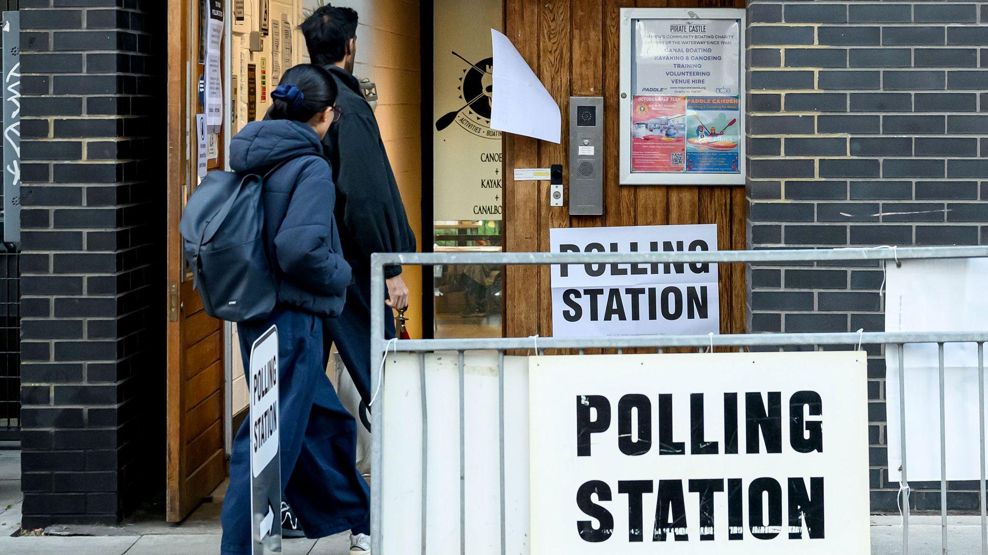 A man and woman enter a polling station as voting continues in the Holborn and St Pancras by-election on October 08, 2026 in London, England.