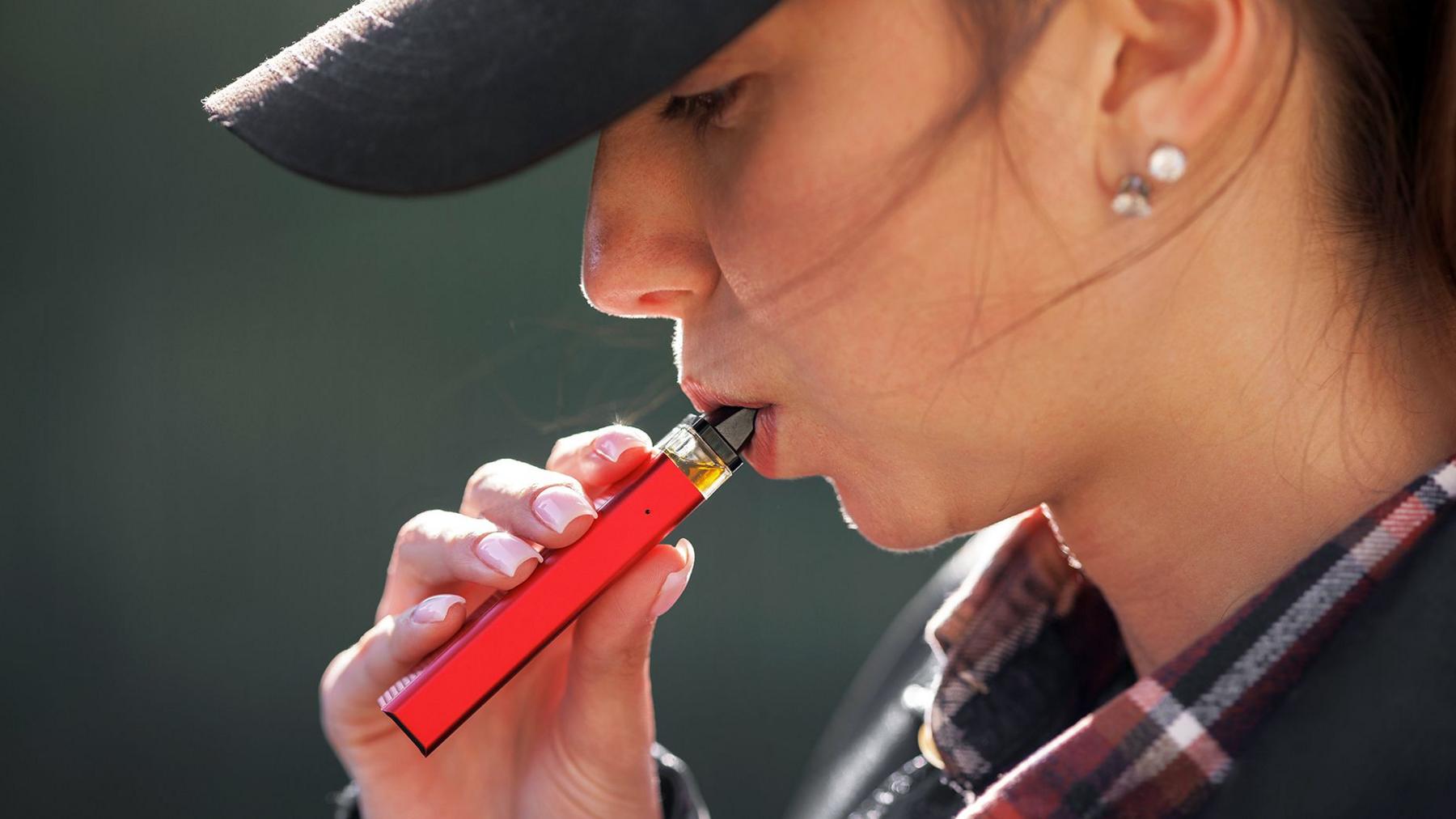 A stock image of a young woman vaping