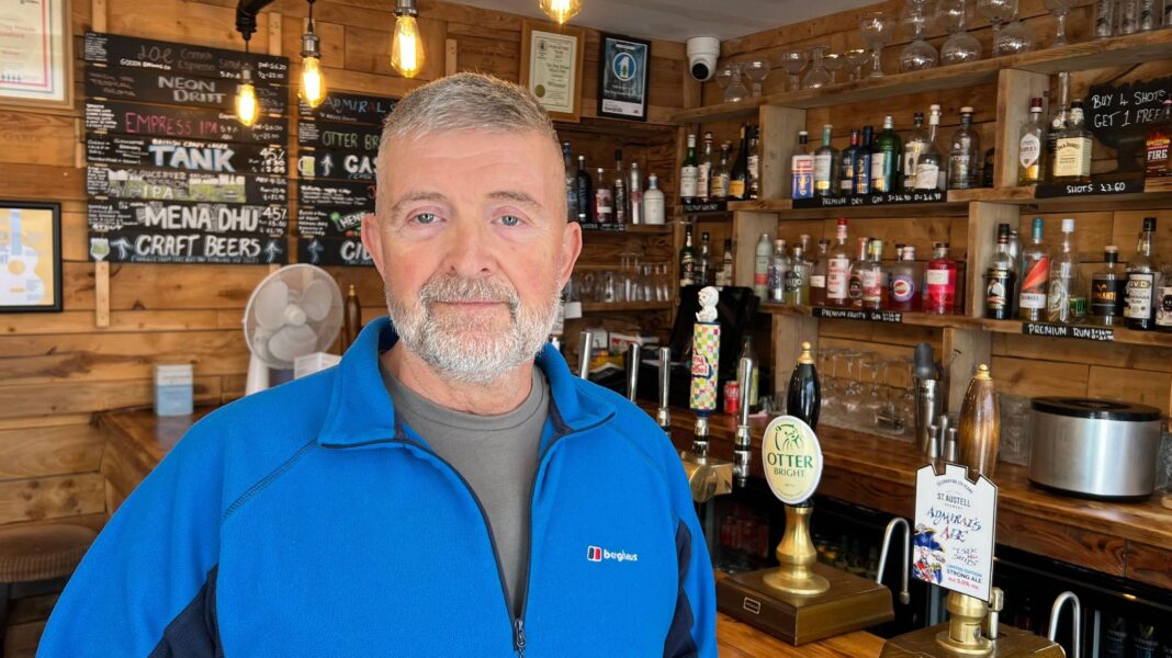 Men abused woman advertised by husband, court told A man in a blue top standing in a wooden bar area in a pub.