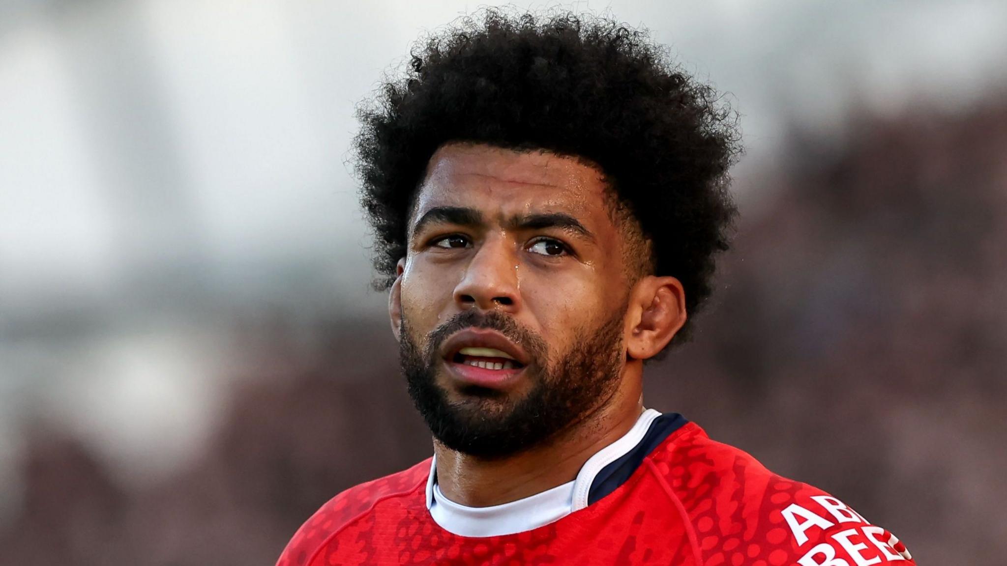 Head and shoulders view of Kallum Watkins in red England shirt