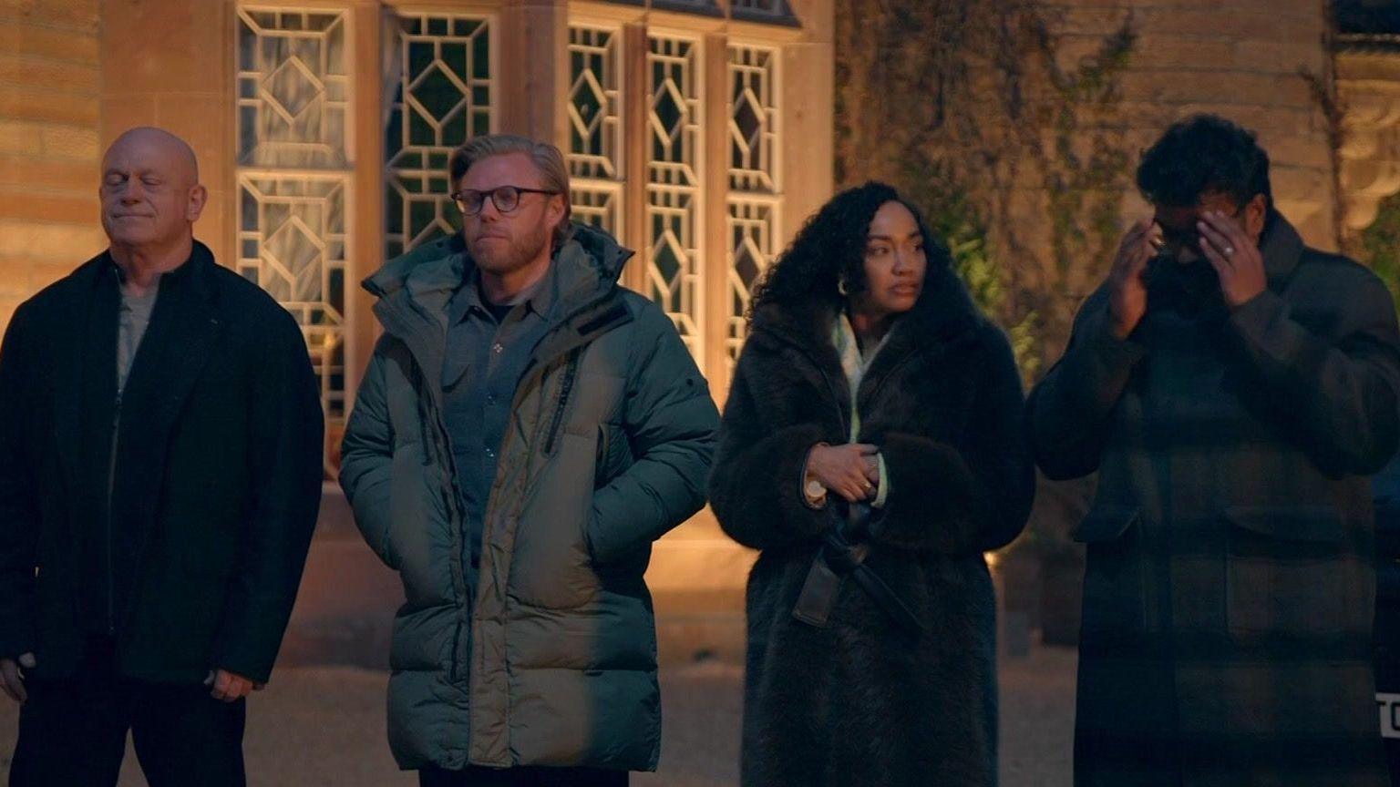 Ross Kemp, Rob Beckett, Leigh-Anne Pinnock and Romesh Ranganathan looking stressed outside the castle at night