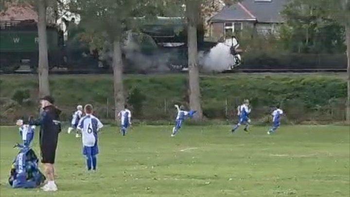Kids in football kits running for a train
