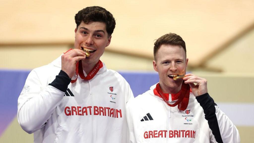 Pilot Steffan Lloyd and James Ball of Team Great Britain celebrate on the podium after the Para-cycling track men's B 1,000m time trial medal ceremony at the Paris 2024 Paralympics