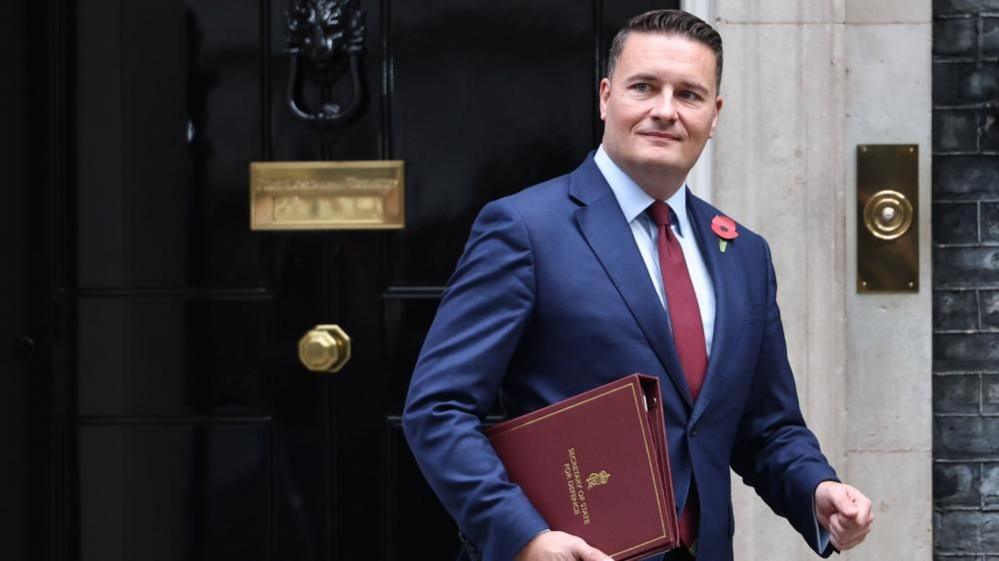 Wes Streeting leaves Number 10 Downing Street while holding a red folder.