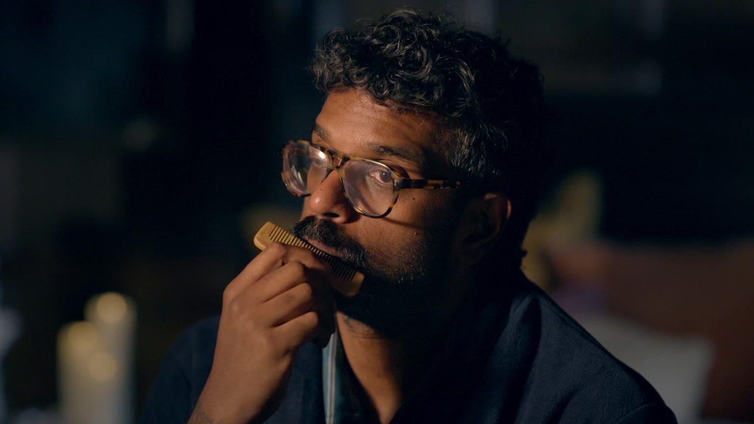 Romesh combing his moustache