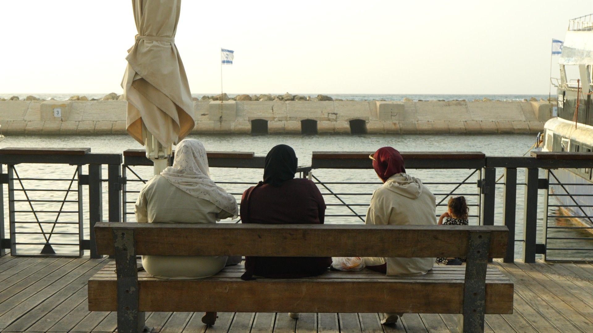 Israeli Arab women sit on a bench at the seafront in Jaffa