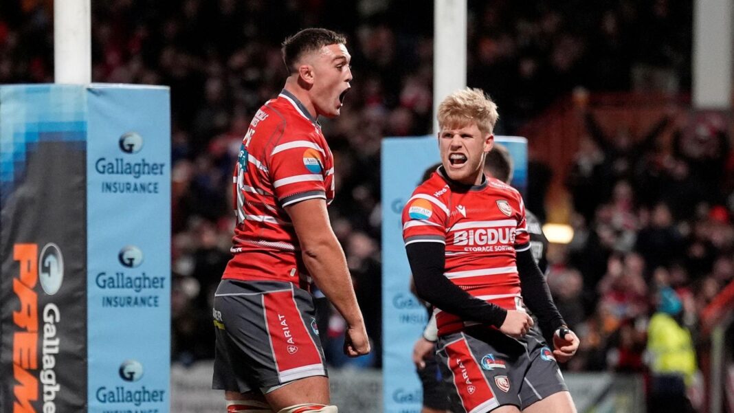Freddie Thomas (left) stands with his fists held low and clenched and George Barton (right) looks to his right at Thomas as the two celebrate a try