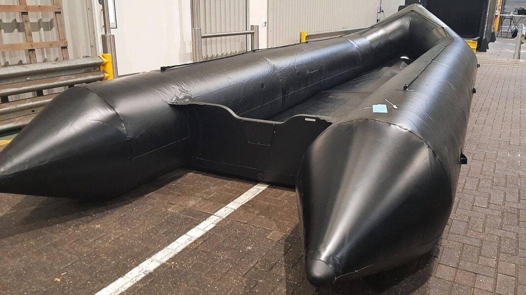 Boats ‘set for people smugglers’ seized at UK airport for the first time A large black inflatable boat in a warehouse.