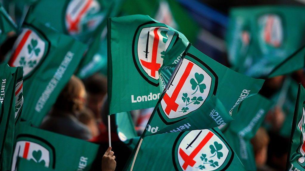 London Irish fans wave flags during the Aviva Premiership match between London Irish and Gloucester Rugby at the Madejski Stadium in 2016