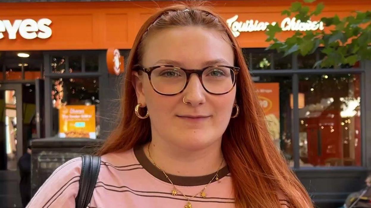 Mackenzie Bird wearing glasses and a pink and brown striped t-shirt