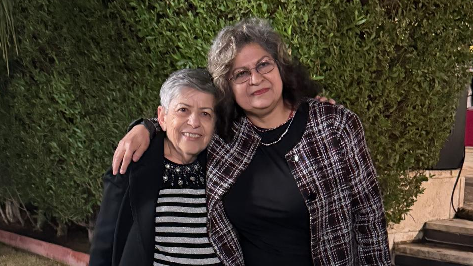 Iraqi women's rights activists Hanaa Edwar (left) and Yanar Mohammed, pictured together shortly before Mohammed was killed. Edwar has short grey hair and a black and white striped top, while Mohammed has longer brown hair and glasses and is wearing a checked jacket. Both are smiling and Mohammed has her arm around Edwar's shoulders.