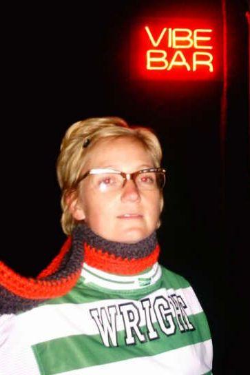 A blonde woman - wearing a red and black scarf - sports Kevin's green and white hooped Celtic shirt outside the Vibe Bar in Barcelona.