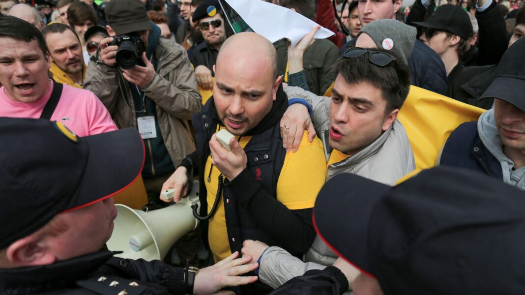 They fled Russia, but the West sent them back Andrei Pivovarov is at the centre of the shot speaking into a megaphone and is surrounded by other protestors. Russian police are approaching him and reaching towards him.