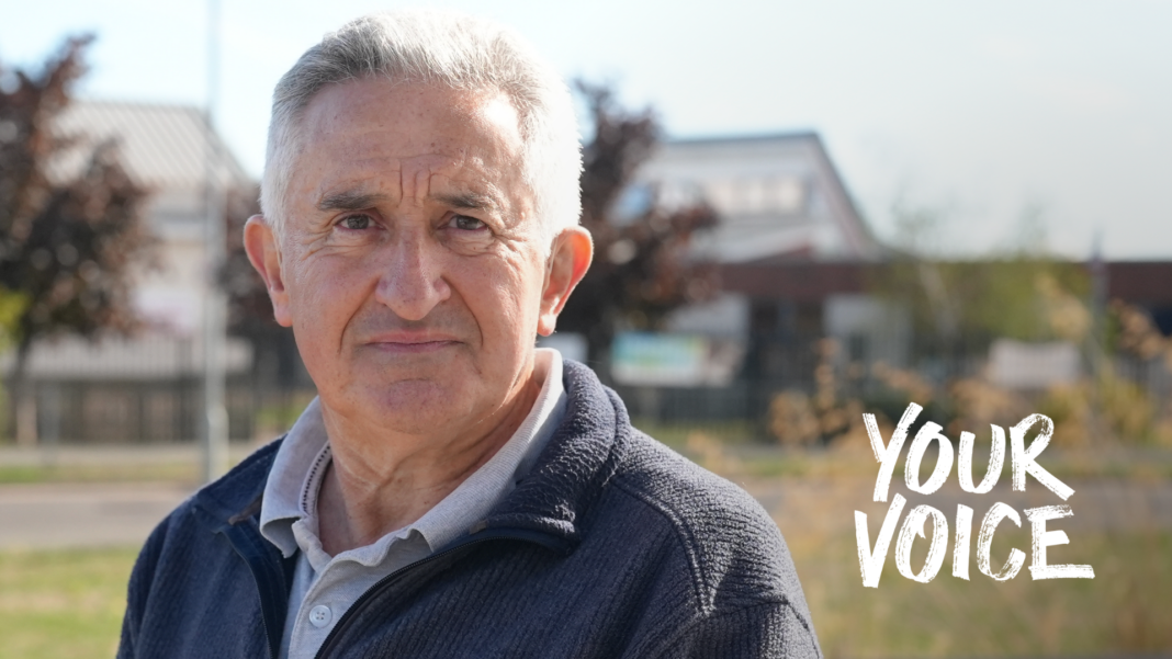 Royal Mail losing 400 postal workers a week, says union Bryn Dymott, wearing a polo shirt and cardigan, standing on grass in front of some buildings blurred in the background. The words "Your Voice" are imposes on the photo on the left.