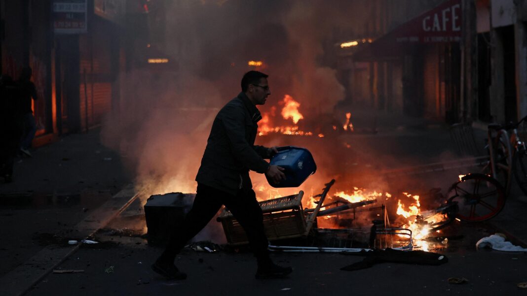 Macron calls for ‘calm and order’ after riots across France A man tries to extinguish a fire, during civil unrest, the day after a national day of demonstrations against the cost of living and rising fuel prices, in Paris, France, October 18, 2026.